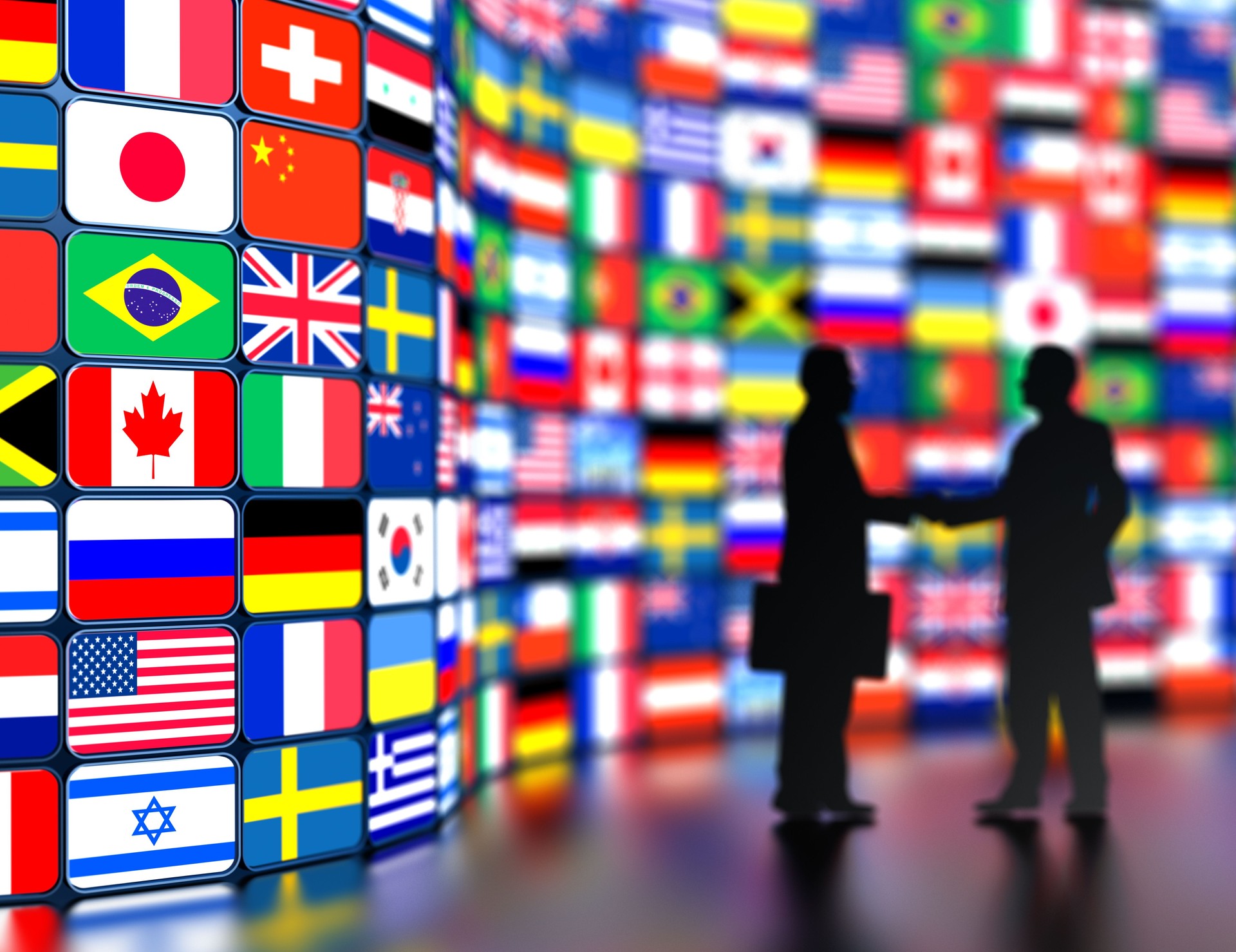 Businessmen shaking hands in front of the world flags
